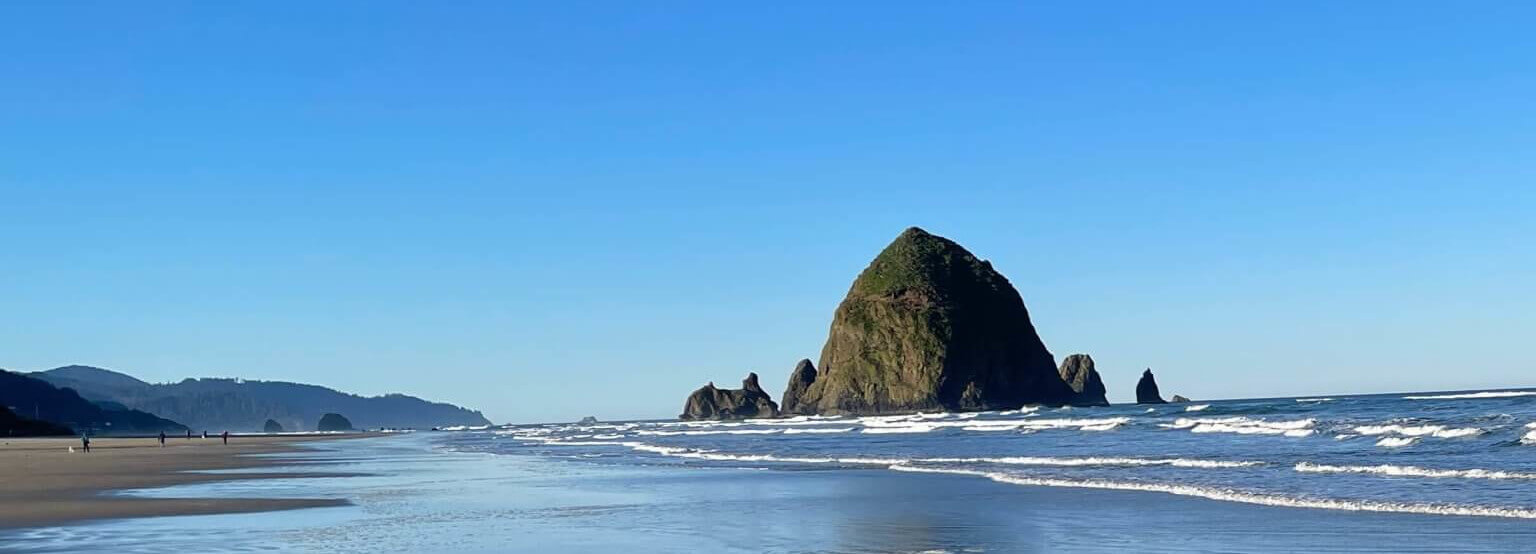 Cannon Beach vs Astoria.  Haystack rock appears near the shore of Cannon Beach, Oregon